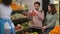 Young couple choosing vegetables in supermarket