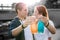 Young couple clanging bottles with colorful lemonade and smiling