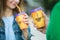 Young couple with coffee cups in hands, walking in park.