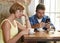 Young couple at coffee shop with internet and mobile phone addict man ignoring frustrated woman