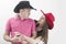 Young couple with cowboy hats making silly faces on white