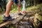 A young couple is crossing a creek while hiking. Hiking, nature, relationship, together