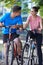 Young Couple Cycling Next To River In Urban Setting