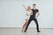 Young couple dancing latin music: Bachata, merengue, salsa. Two elegance pose on white room