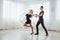 Young couple dancing latin music: Bachata, merengue, salsa. Two elegance pose on white room