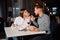 Young couple on a date. A man feeds his woman a delicious dessert. Couple laughing in the restaurant