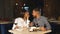 Young couple on a date. A man feeds his woman a delicious dessert. Couple laughing in the restaurant