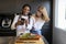 Young couple of different ethnic groups with mobile phone in a kitchen with vegetable board. concept of healthy living