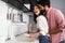 Young couple doing dishes in the kitchen while hugging and having fun