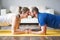 Young couple doing exercise at home in living room.