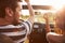 Young Couple Driving Along Country Road In Open Top Car