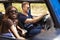 Young Couple Driving Open Top Car On Country Road