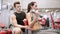 Young couple with dumbbell flexing muscles in gym