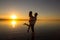 Young couple is embracing in the water on summer beach. Sunset over the sea.Two silhouettes against the sun. Just married couple