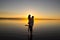 Young couple is embracing in the water on summer beach. Sunset over the sea.Two silhouettes against the sun. Just married couple