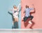 Young couple, emotional man and pretty woman messing about isolated over blue and pink background. Human emotions, youth