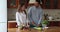 Young couple enjoy conversation while cooking salad in kitchen