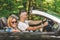 Young couple enjoying road trip inside of their convertible car.