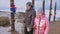 Young couple enjoying walking outdoors in winter top mountains. Buddhist Ritual poles with colored ribbons in the winter