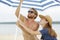 young couple erecting parasol on beach