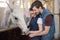 Young couple feeding beautiful white purebred horse