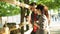 Young couple feeding feeding guanaco in farm on sunny evening. Man feeds lama with carrot. Boyfriend and girlfriend have