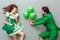 Young couple in festive costumes saint patrick`s day top view giving present