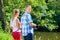 Young couple fishing or angling standing on river shore