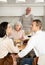 Young couple flirting sitting around table together with old family members looking with objection