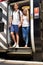 Young Couple Getting Off Train At Platform