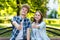 Young couple girl and boy. Summer in park on a bench. Smiles happily. Hard hands showing thumbs up, like. Emotionally