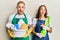 Young couple of girlfriend and boyfriend wearing apron holding products and cleaning spray celebrating crazy and amazed for
