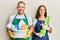 Young couple of girlfriend and boyfriend wearing apron holding products and cleaning spray smiling with a happy and cool smile on