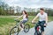Young couple going on a bike on a sunny day in a city park.