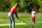 Young couple on a golfing vacation, man teeing off