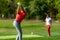 Young couple on a golfing vacation, man teeing off