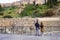 Young couple: a guy and a girl with a backpack visiting the Roman theater of Malaga. Ruin.