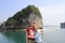 Young couple guy and girl in sportswear hugging and laughing happily against the background of the cliffs of Ha Long Bay during th