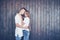 Young couple, guy and girl together on a wooden wall background. They are happy together and dressed alike. Always in a