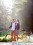 Young couple, handsome man and attractive woman on tandem bike in sunny summer park or forest.