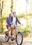 Young couple, handsome man and attractive woman on tandem bike in sunny summer park or forest.