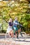 Young couple, handsome man and attractive woman on tandem bike in sunny summer park or forest.