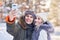 Young couple having fun on snow taking selfie