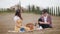 A young couple having a picnic - talking and eating fruits - Tuscany