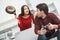 Young couple having romantic evening at home irritated wife with pan