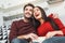 Young couple having romantic evening at home together watching comedy show