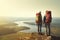 A young couple in hiking clothes on a rocky outcrop looking down into the valley. Generative AI