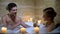 Young couple holding champagne glasses in bathroom with candles, romantic