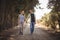 Young couple holding hands while walking on dirt road at olive farm