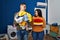 Young couple holding laundry dirty and clean laundry smiling looking to the side and staring away thinking